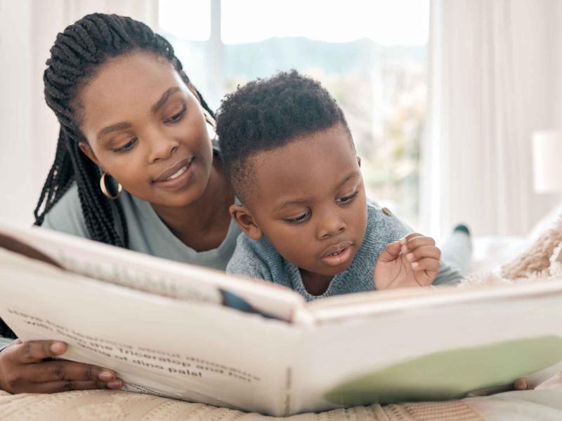 woman reads a book to a young boy