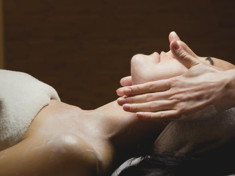 A person receiving a facial massage at Milk + Honey