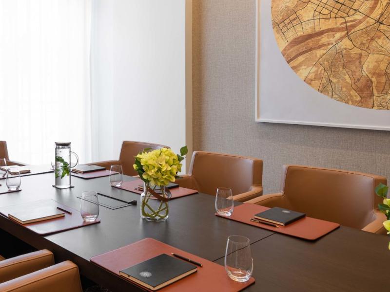 The Sky Boardroom at Viceroy Kopaonik Serbia, with office chairs surrounding a long meeting table and a large art piece on the wall