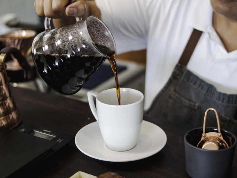 A server pours a coffee at Otro Bar