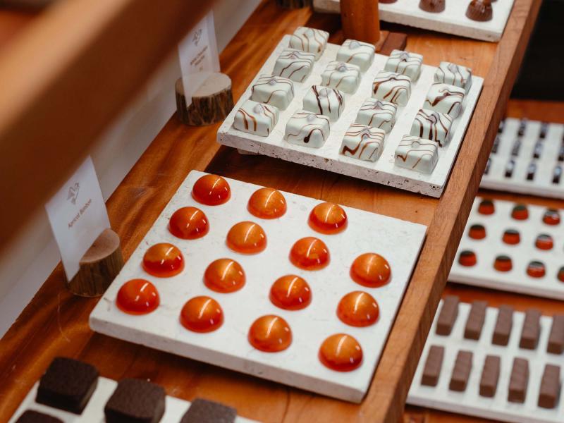 Uma vitrina com chocolates castanhos e laranja