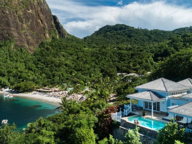 A villa with a private pool, looking out on a secluded beach at the foot of a mountain