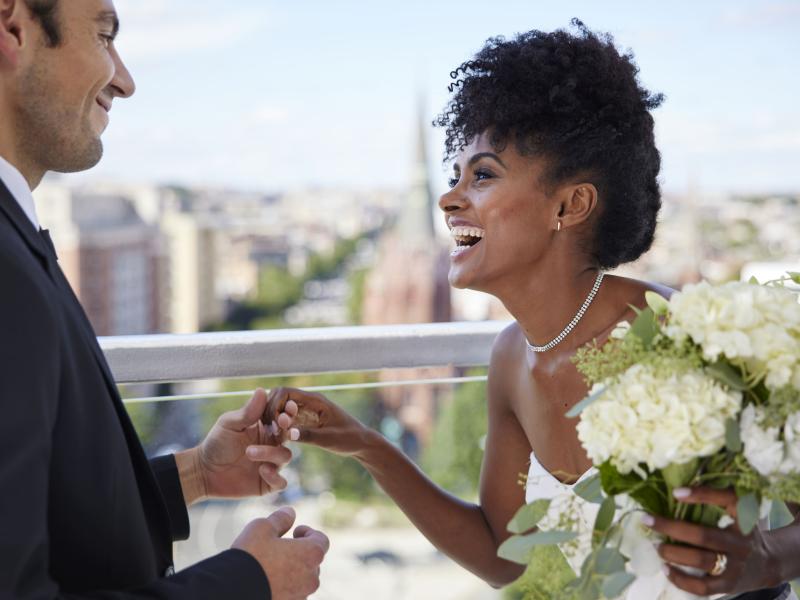 A bride and groom holding hands and laughing on the rooftop patio at Hotel Zena, Washington DC